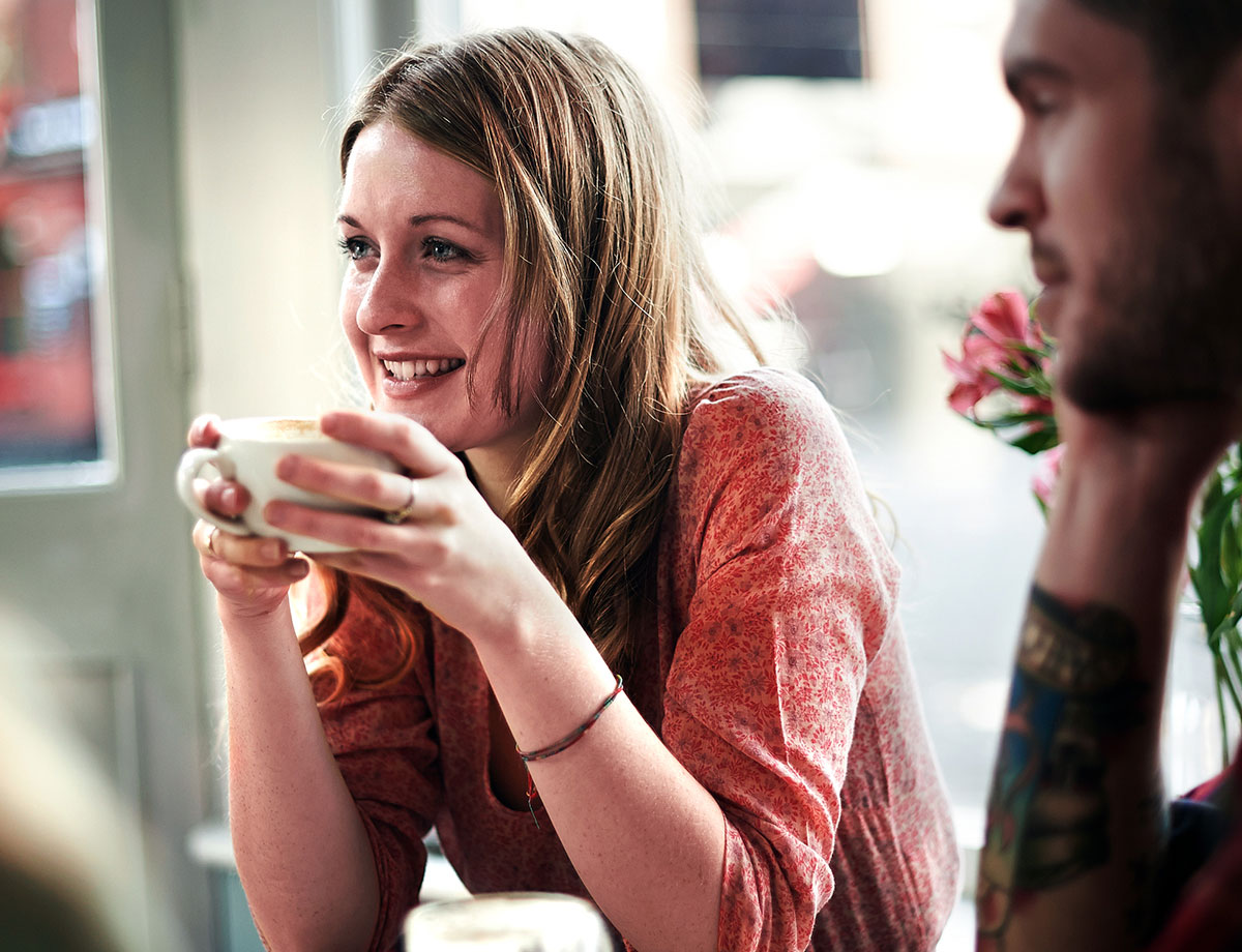 smiling woman having a cup of coffee in a coffee shop